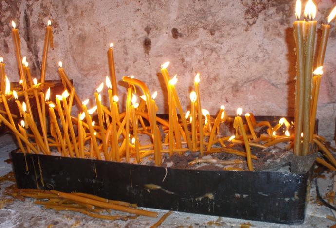 Свечи на полу храма в память о погибших сербах